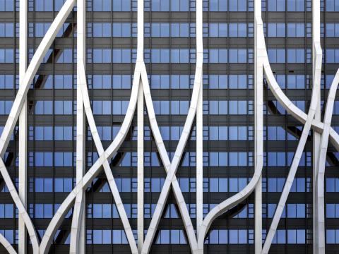 Fascade of a blue windowed building with steel trusses