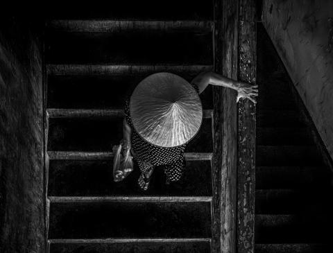 A woman descends a stairwell in District 4 — a building marked for imminent demolition