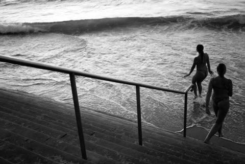 2 friends enter Indian Ocean at Cottesloe for an evening swim 