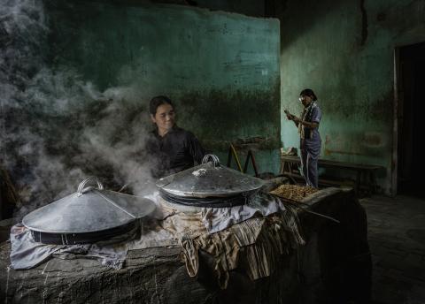 Asian street with noodle makers and pots with steam